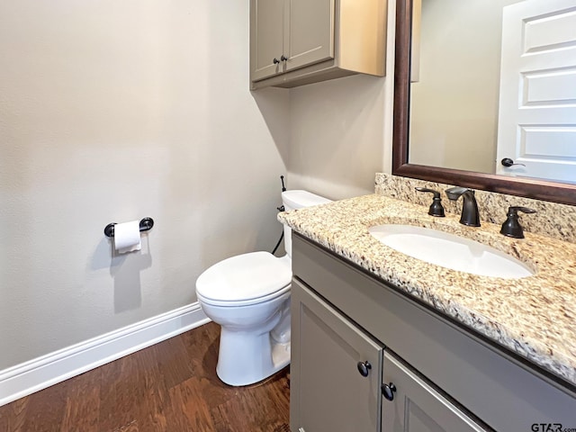 bathroom featuring wood-type flooring, toilet, and vanity