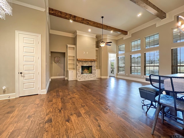 living room with ceiling fan, a towering ceiling, ornamental molding, dark hardwood / wood-style flooring, and beamed ceiling