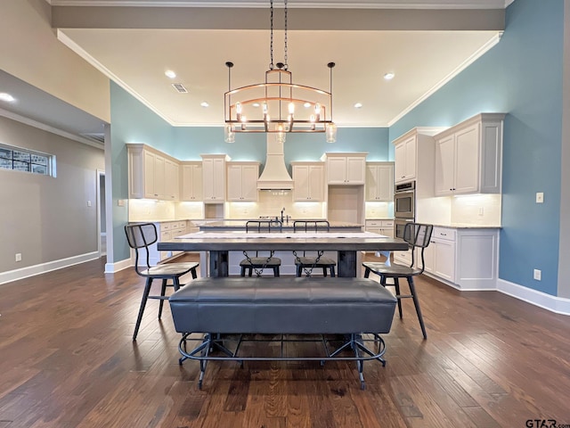 dining area with a notable chandelier, sink, ornamental molding, and dark hardwood / wood-style floors