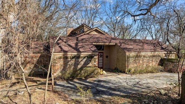 exterior space featuring a chimney and brick siding