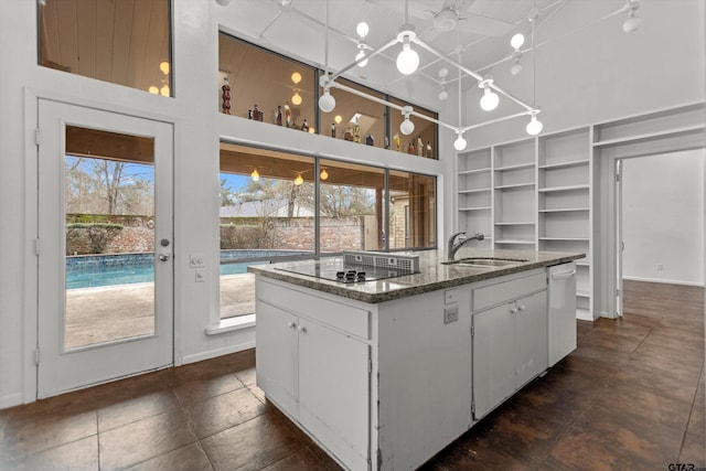 kitchen featuring black electric stovetop, a sink, white cabinetry, dishwasher, and a center island with sink