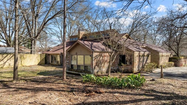 back of house with fence and brick siding