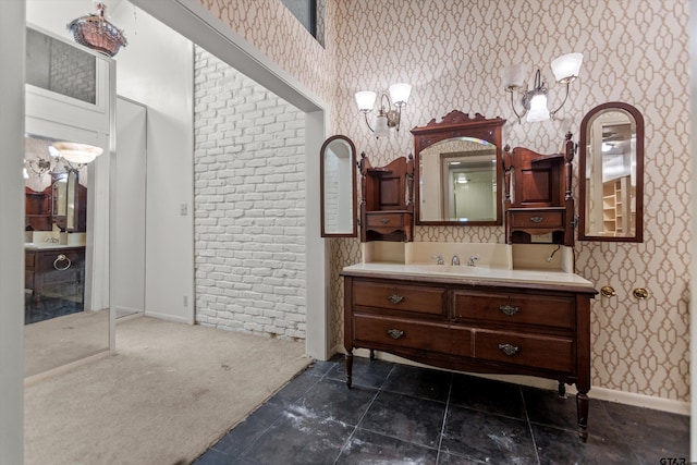 bathroom featuring vanity, baseboards, and wallpapered walls