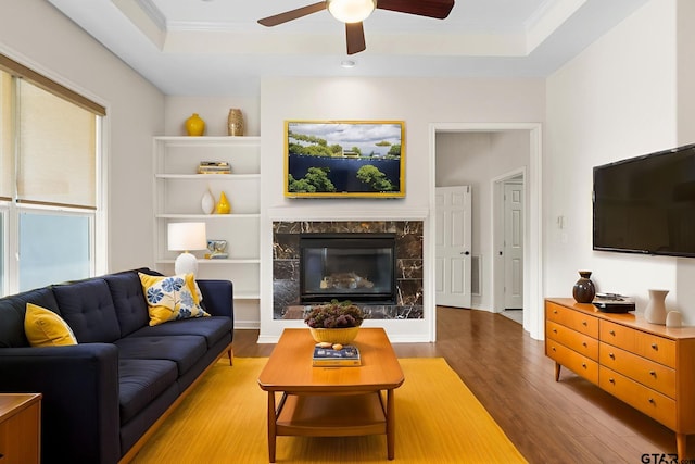 7031 Ridge Place Cir, Tyler, TX 75703 - living area featuring a tray ceiling, wood finished floors, ceiling fan, a high end fireplace, and crown molding