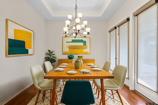 7031 Ridge Place Cir, Tyler, TX 75703 - dining space featuring wood finished floors, a chandelier, and a raised ceiling