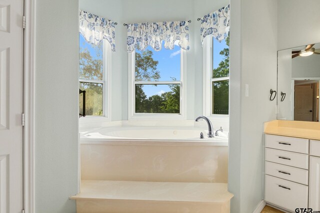 7031 Ridge Place Cir, Tyler, TX 75703 - bathroom with vanity, a garden tub, and a ceiling fan