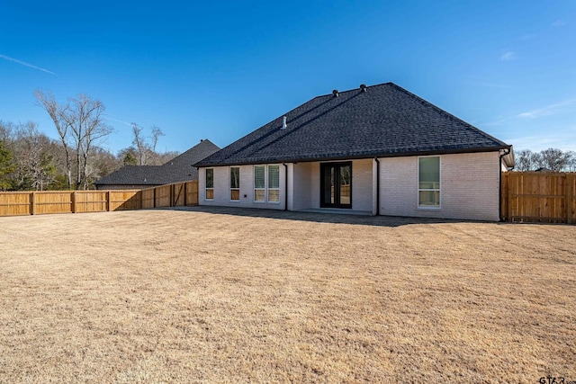 rear view of property with a yard