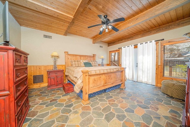 bedroom with visible vents, wooden ceiling, a wainscoted wall, stone floors, and beam ceiling