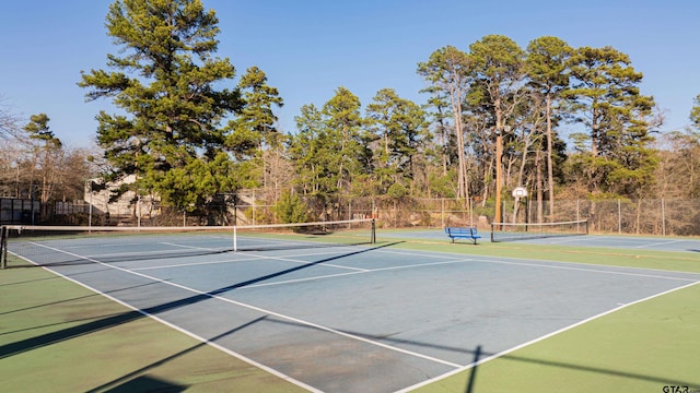 view of tennis court featuring fence