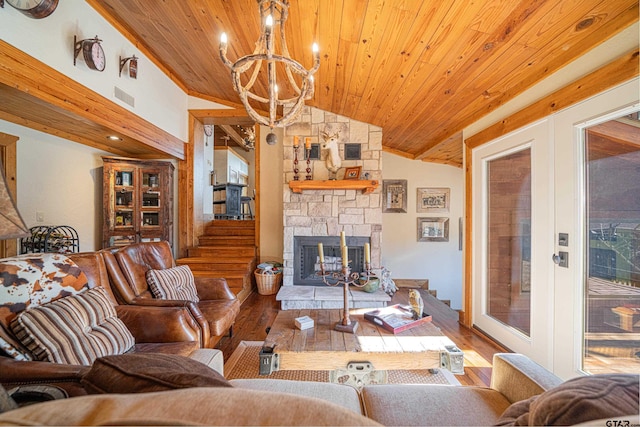 living room with a stone fireplace, a notable chandelier, wood finished floors, wood ceiling, and vaulted ceiling