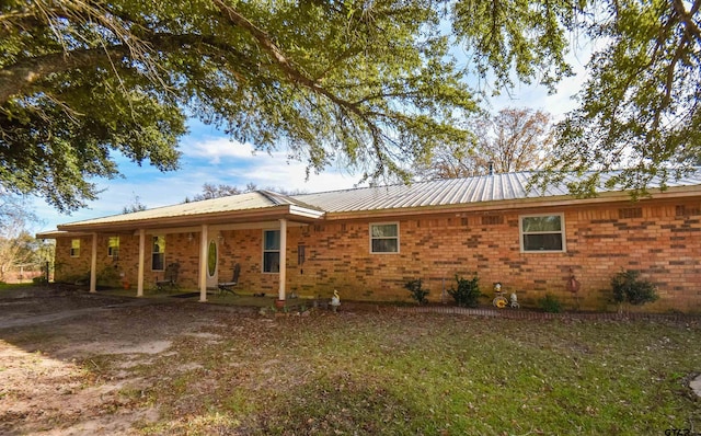 rear view of property featuring a lawn