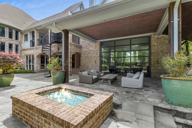 view of patio featuring an outdoor living space with a fire pit