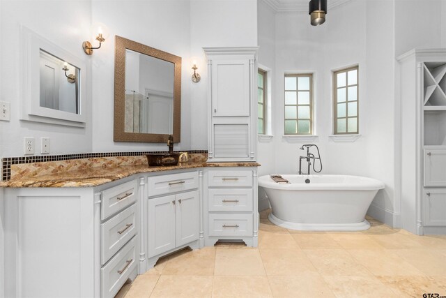 bathroom with tile patterned flooring, a high ceiling, vanity, and a bathtub