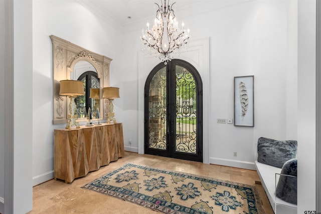 entryway featuring crown molding, french doors, and a notable chandelier