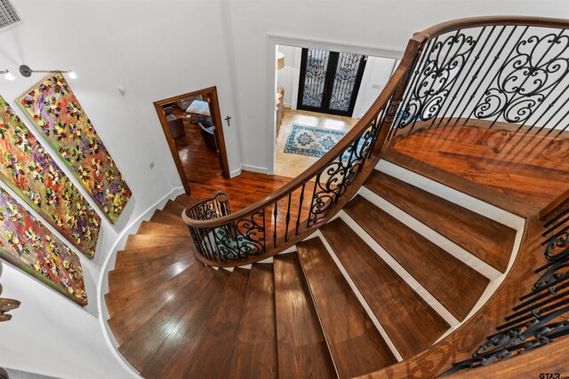 stairway featuring french doors and wood-type flooring