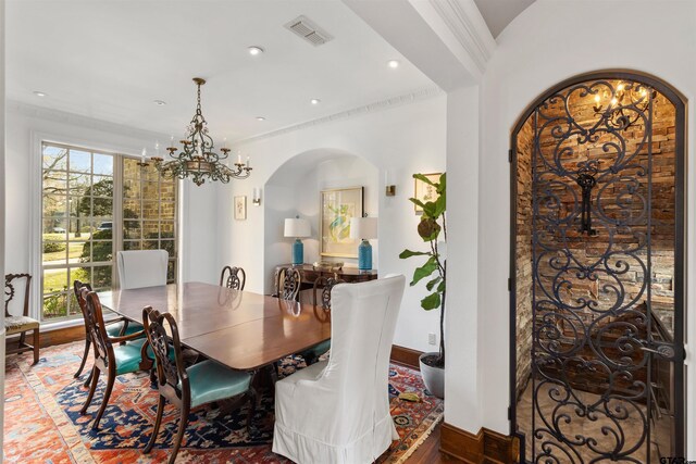 dining area with a wealth of natural light, a notable chandelier, and ornamental molding