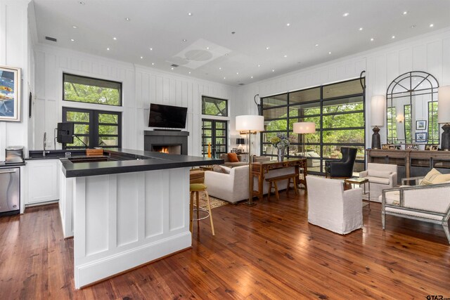 kitchen featuring a center island, white cabinetry, dark wood-type flooring, and a breakfast bar area