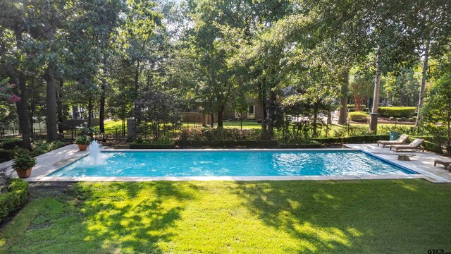 view of swimming pool featuring a lawn