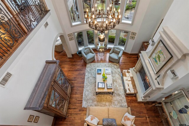 living room with a towering ceiling, dark hardwood / wood-style floors, and a notable chandelier