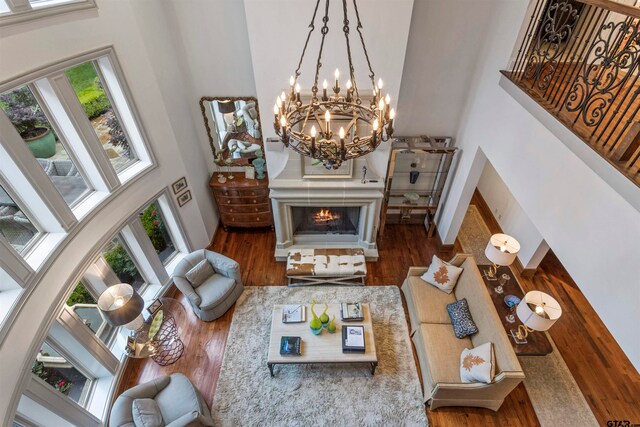 living room with a chandelier, dark hardwood / wood-style floors, and a high ceiling