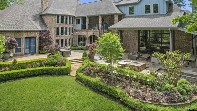 back of house featuring outdoor lounge area, a yard, a patio, and french doors