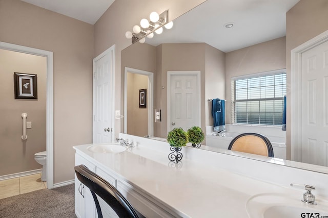 bathroom with toilet, vanity, and tile patterned floors