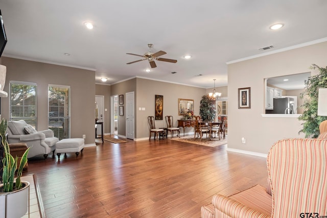 living room featuring ornamental molding, ceiling fan with notable chandelier, and hardwood / wood-style flooring