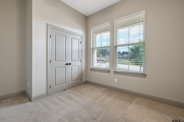 unfurnished bedroom featuring baseboards, a closet, and carpet
