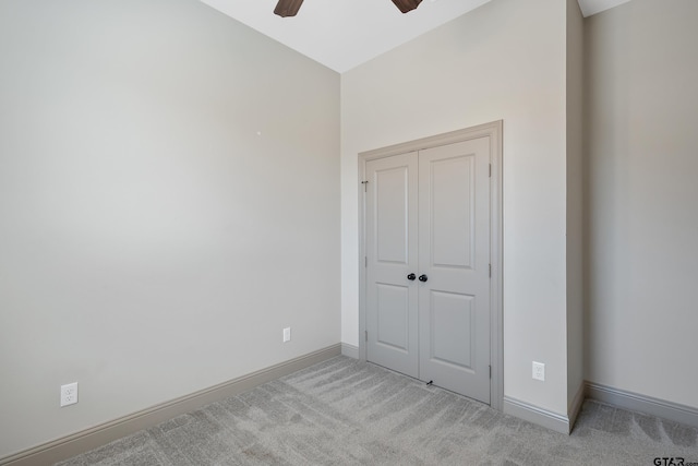 unfurnished bedroom featuring baseboards, carpet flooring, a closet, and ceiling fan