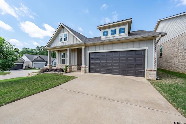 view of front of property featuring a porch, concrete driveway, a garage, board and batten siding, and a front yard