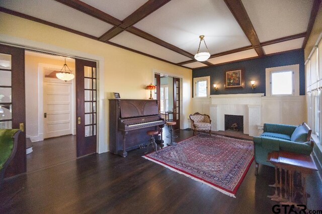 living room featuring beamed ceiling, dark hardwood / wood-style floors, a fireplace, and coffered ceiling