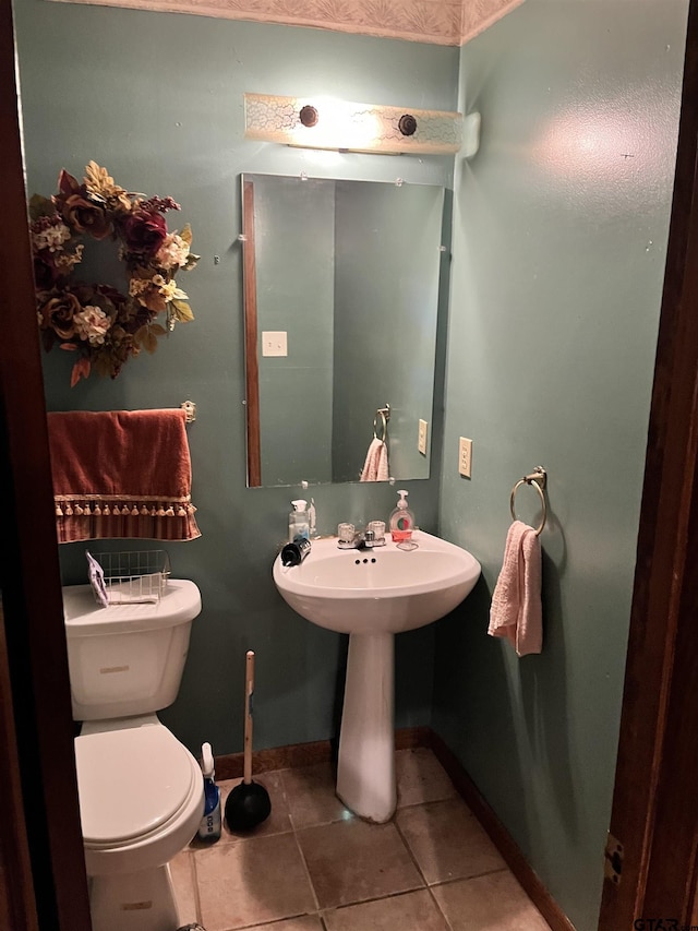 712 Leon Dr, Tyler, TX 75702 - half bath featuring tile patterned flooring, toilet, baseboards, and a sink