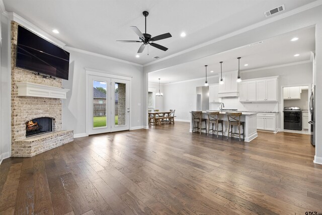 11918 Gillian Ct, Tyler, TX 75703 - living room featuring a ceiling fan, dark wood finished floors, ornamental molding, recessed lighting, and a fireplace