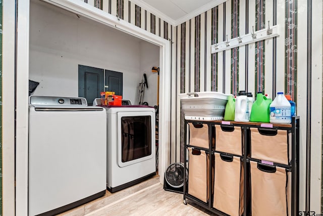 washroom with light wood-type flooring, ornamental molding, and washing machine and clothes dryer