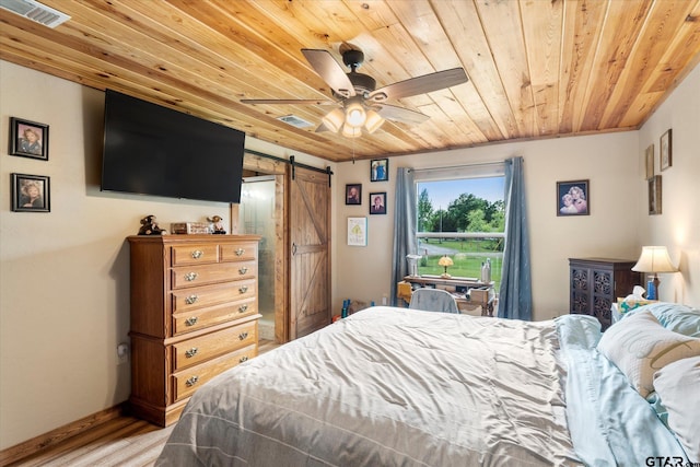 111 Little River Bnd, Quitman, TX 75783 - bedroom with wooden ceiling, light wood-style flooring, a barn door, and visible vents
