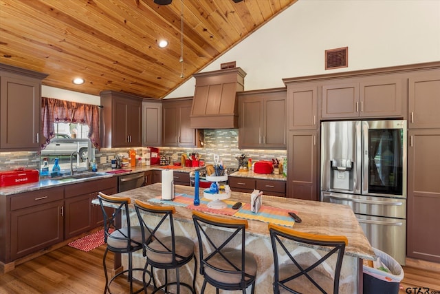 111 Little River Bnd, Quitman, TX 75783 - kitchen with wood ceiling, a kitchen breakfast bar, custom range hood, a sink, and appliances with stainless steel finishes