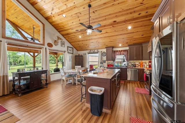 111 Little River Bnd, Quitman, TX 75783 - kitchen with stainless steel appliances, a kitchen island, wooden ceiling, wood finished floors, and high vaulted ceiling