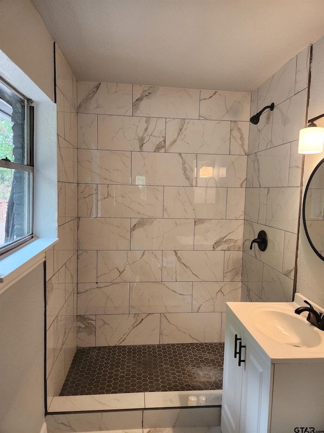 bathroom with vanity and tiled shower