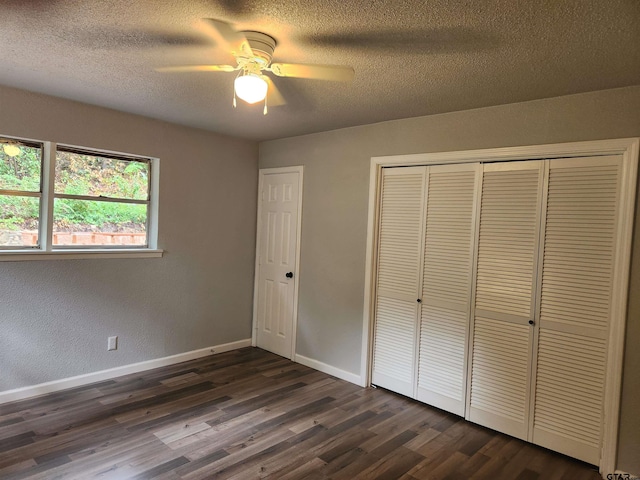 unfurnished bedroom with a textured ceiling, ceiling fan, and dark wood-type flooring