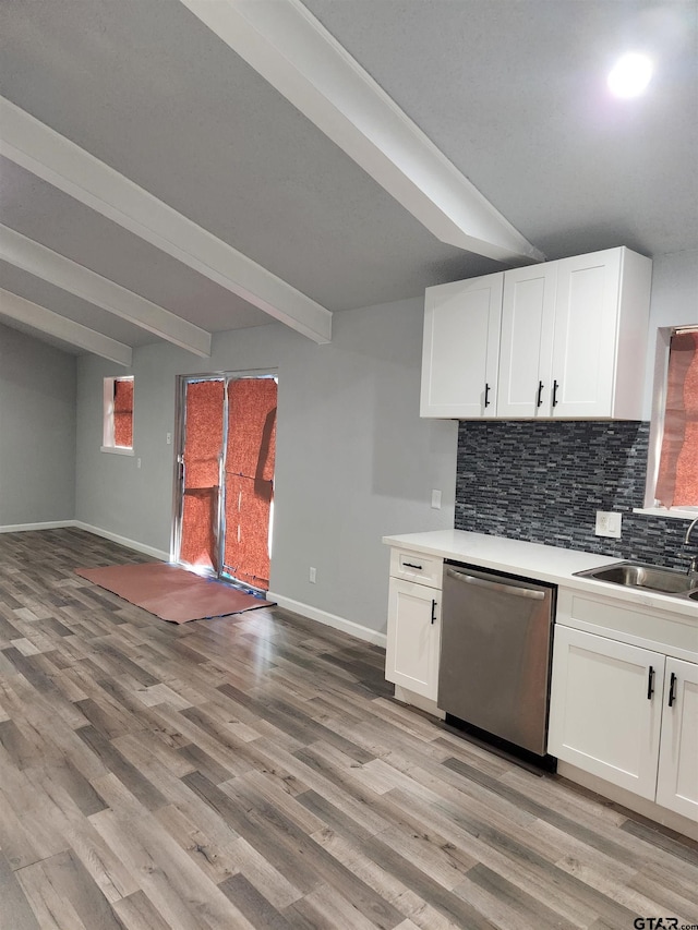 kitchen with beam ceiling, white cabinetry, dishwasher, and sink