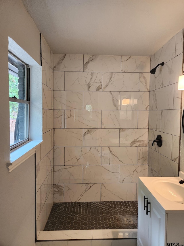 bathroom with vanity and tiled shower