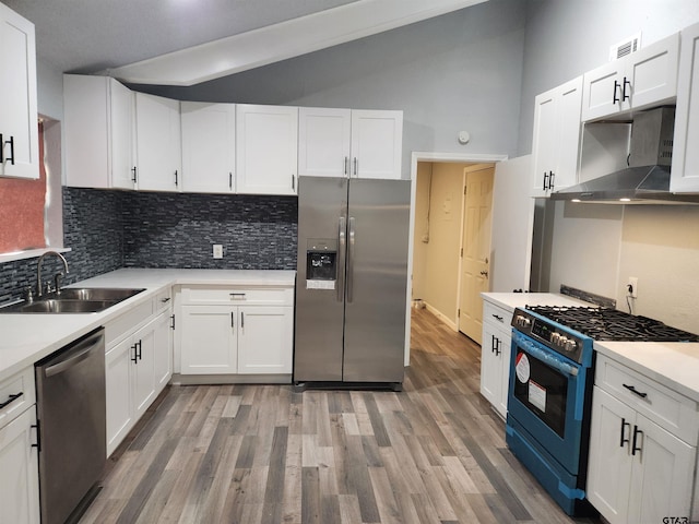 kitchen with sink, stainless steel appliances, range hood, vaulted ceiling, and white cabinets