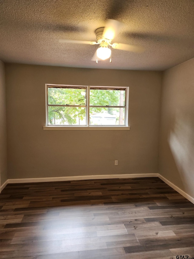 spare room with a textured ceiling, ceiling fan, and dark wood-type flooring