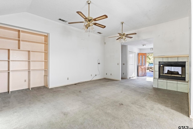 unfurnished living room with a fireplace, ceiling fan, lofted ceiling, and carpet floors