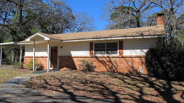 view of front of home featuring brick siding and a chimney