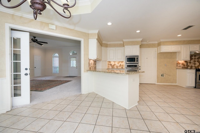 5607 Bostick Dr, Tyler, TX 75707 - kitchen featuring stainless steel appliances, light tile patterned flooring, light stone countertops, ornamental molding, and decorative backsplash