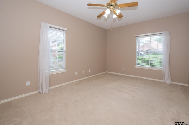 5607 Bostick Dr, Tyler, TX 75707 - empty room with light colored carpet, plenty of natural light, ceiling fan, and baseboards