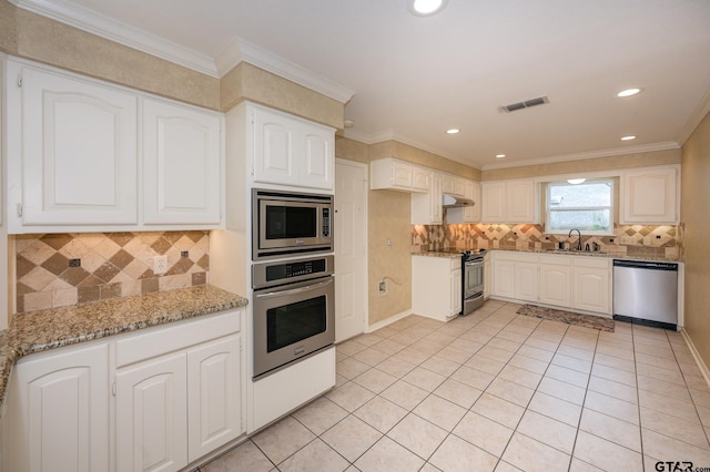 5607 Bostick Dr, Tyler, TX 75707 - kitchen featuring stainless steel appliances, a sink, light stone counters, backsplash, and ornamental molding