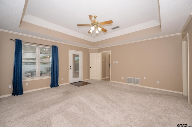 5607 Bostick Dr, Tyler, TX 75707 - carpeted empty room featuring a tray ceiling, ceiling fan, ornamental molding, and baseboards