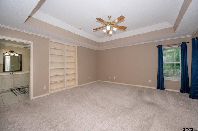 5607 Bostick Dr, Tyler, TX 75707 - unfurnished bedroom featuring a tray ceiling, light colored carpet, baseboards, crown molding, and a sink